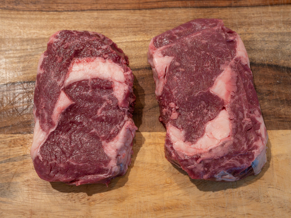 Two Revival Cattle Co. ribeye steaks on a cutting board